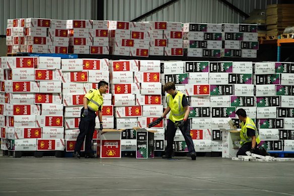 Australian Border Force officers checking illegal cigarette imports found in shipping containers.