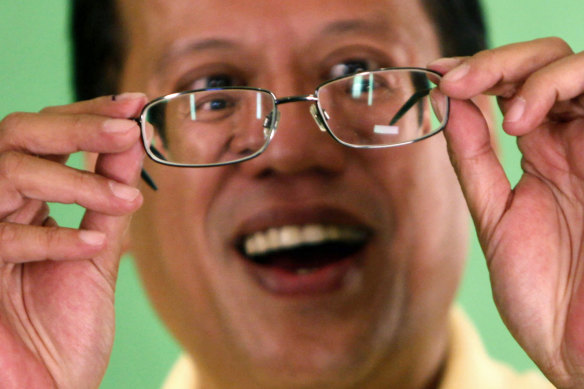Then still a candidate, Benigno Aquino checks his glasses prior to a live television interview in 2010.