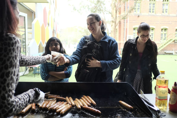 Voters enjoy an election day sausage sizzle at Carlton Gardens Primary School in 2013.
