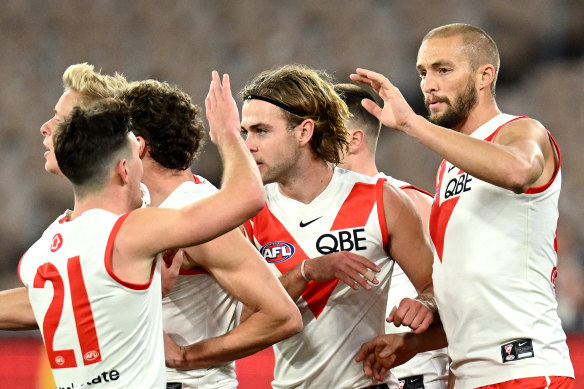 Sam Reid is congratulated after kicking one of his three goals against Melbourne.