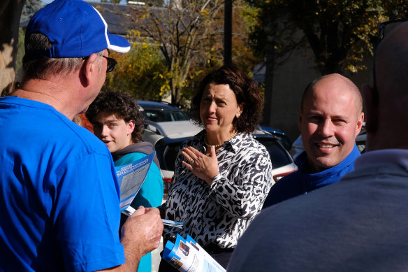 Josh Frydenberg and independent Kooyong candidate Monique Ryan hand out how-to-vote cards to  people attending the Hawthorn pre-polling booth.
