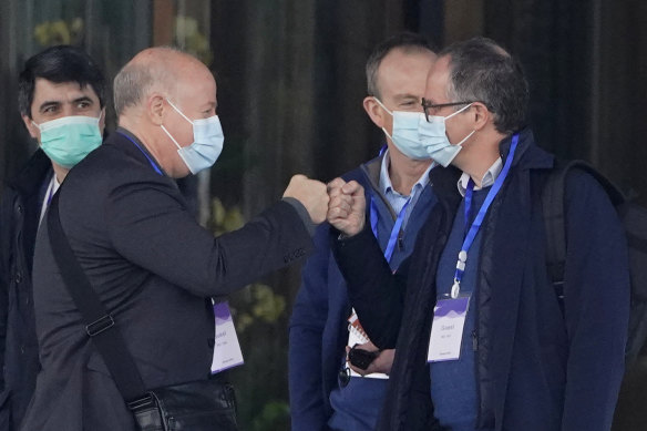 WHO investigator Peter Daszak, left, bumps fists with Peter Ben Embarek during their field visit in Wuhan.