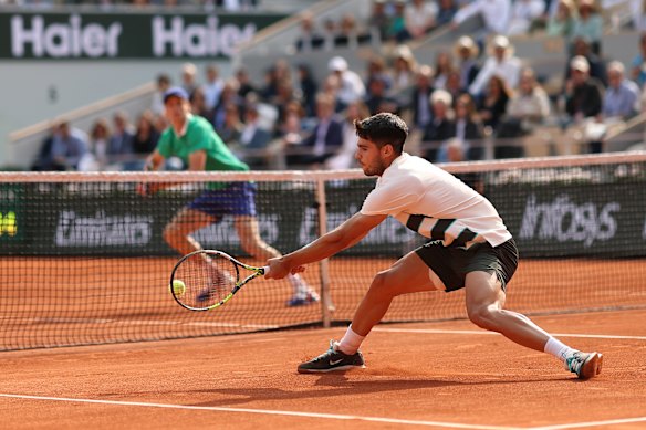 Carlos Alcaraz plays a backhand at the net against Jannik Sinner during an epic contest in Paris.