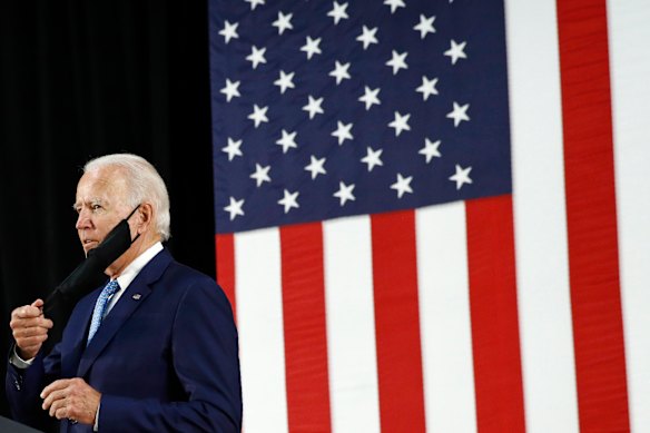 Democratic presidential candidate Joe Biden removes a face mask to protect against the spread of the new coronavirus.  