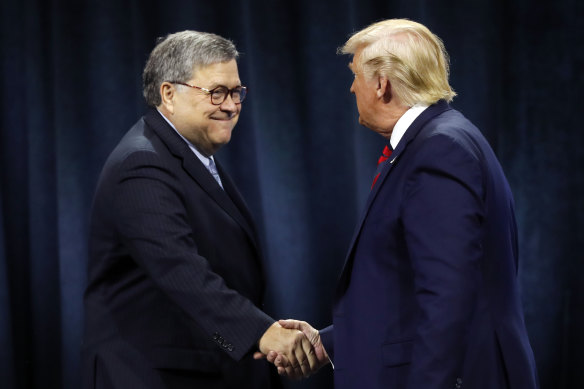 US President Donald Trump shakes hands with Attorney-General William Barr.