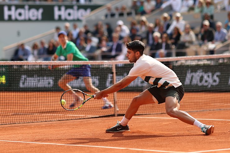 Carlos Alcaraz plays a backhand at the net against Jannik Sinner during an epic contest in Paris.