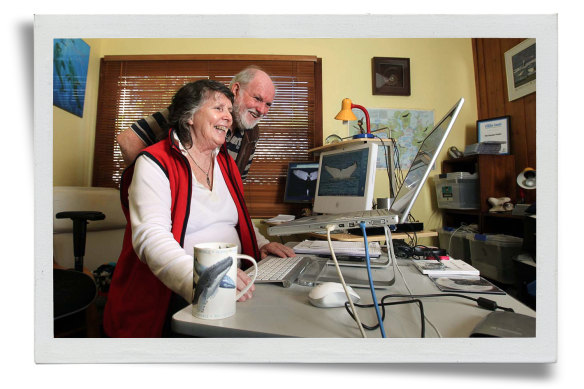 Trish and Wally at home with the database of whale photos Trish has amassed over the years. 