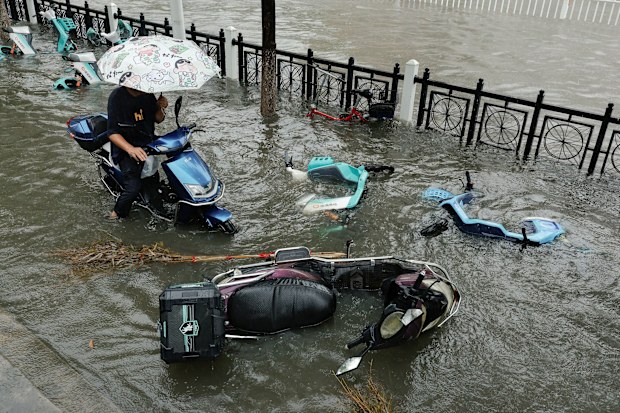 A flooded street is filled with fallen scooters during heavy rain brought by Typhoon Dolphin after it weakened into a tropical storm, in Xiangyang, Hubei province, China this week. Go Nakamura/Reuters via CNN Newsource