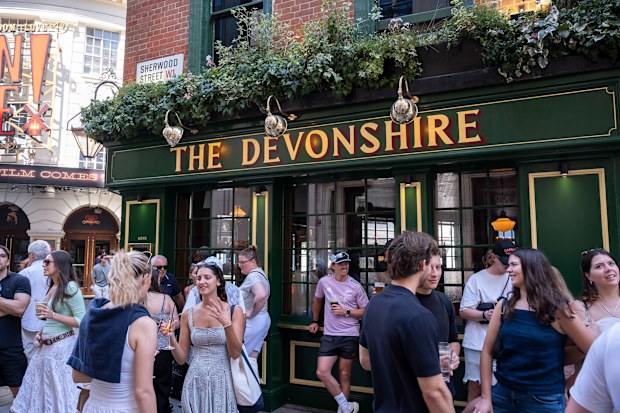 People drinking outside a pub in Soho, London 