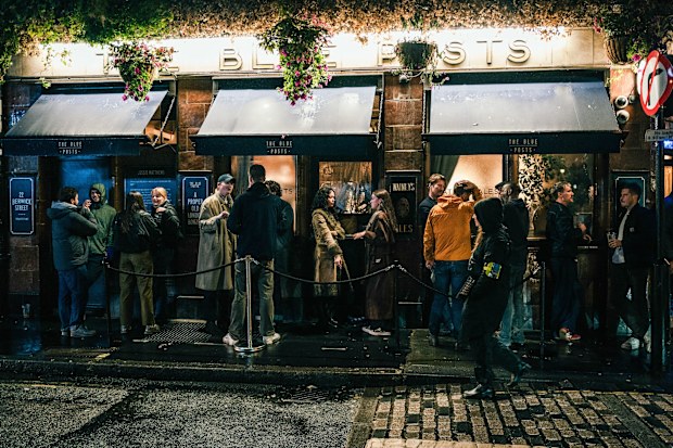 People drinking outside a pub in Soho, London 