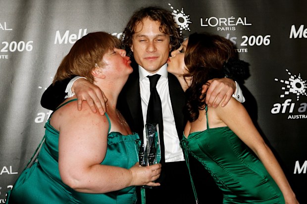 Comedian Magda Szubanski and singer Dannii Minogue kiss actor Heath Ledger,