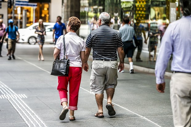 Two old people walk down the street in Brisbane