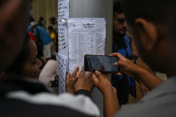 Family members look at a list of missing flood victims at Tribhuvan University Teaching Hospital in Kathmandu, Nepal on Friday.