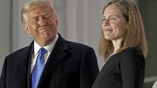 US President Donald Trump, left, rushed the appointment and swearing in of Amy Coney Barrett, associate justice of the US Supreme Court, last month.