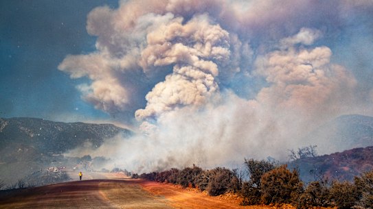 A large smoke plume fills the sky as the Apple fire burns out of control in Cherry Valley, California during August. 