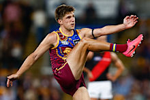 Zac Bailey of the Lions kicks a goal.