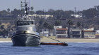 An oil skimming boat works to clean a spill in the waters off Huntington Beach, California.