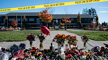 Flowers and candles are seen at a makeshift memorial outside Silver Rail Elementary in Bend, Ore., Friday, Oct. 16, 2026, a day after a deadly shooting. (AP Photo/Joe Kline)