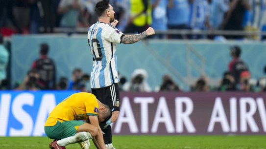 Lionel Messi celebrates as Aziz Behich slumps in defeat.