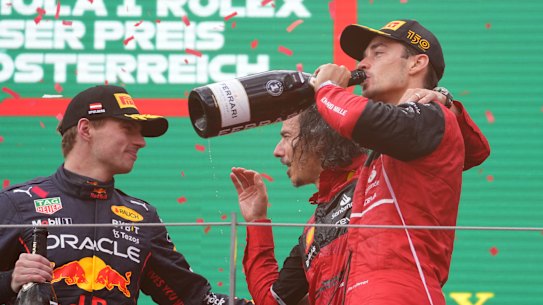Charles Leclerc (right) celebrates his win on the podium.