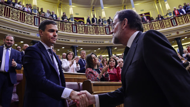 Spain's ousted Prime Minister Mariano Rajoy, right, shakes hands with socialist leader Pedro Sanchez after a motion of no confidence vote at the Spanish parliament in Madrid on Friday