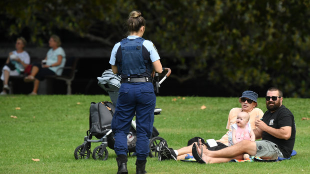 NSW Police ask a family breaching social distancing rules to move on at Sydney's Rushcutters Bay.