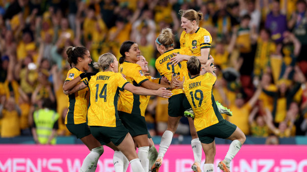 Matildas players and supporters celebrate Cortnee Vine’s winning penalty against France.