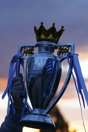 A City supporter holds up a replica of the English Premier League trophy outside the club’s home.