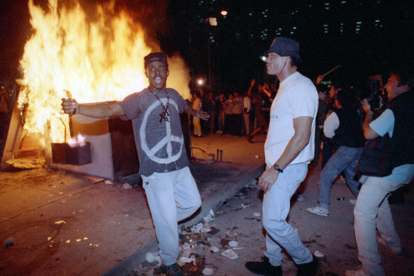 In this April 29, 1992 file photo, demonstrators protest the verdict in the Rodney King beating case in front of the Los Angeles Police Department headquarters in Los Angeles. 