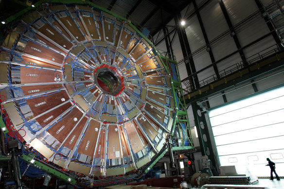 A woman walking beside the LHC’s largest magnet, which helps propel particles along close to the speed of light.