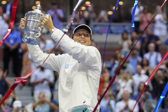 Iga Swiatek, of Poland, holds up the championship trophy after defeating Ons Jabeur, of Tunisia, to win the women’s singles final of the U.S. Open.