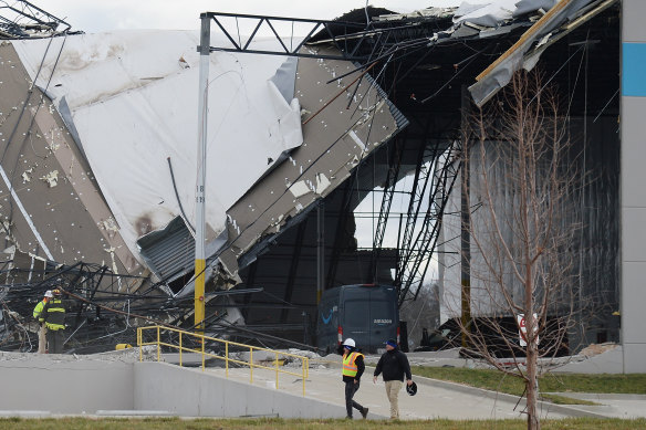 Safety personnel and first responders survey a damaged Amazon Distribution Centre in Edwardsville, Illinois.
