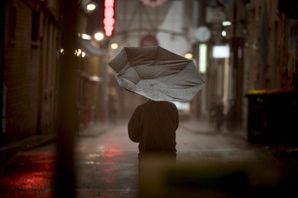 Pedestrians take cover as severe storms have hit Melbourne’s CBD. 