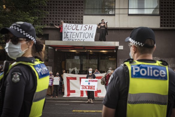 Police and refugee advocates outside the Park Hotel, which is where a number of refugees are also being detained.