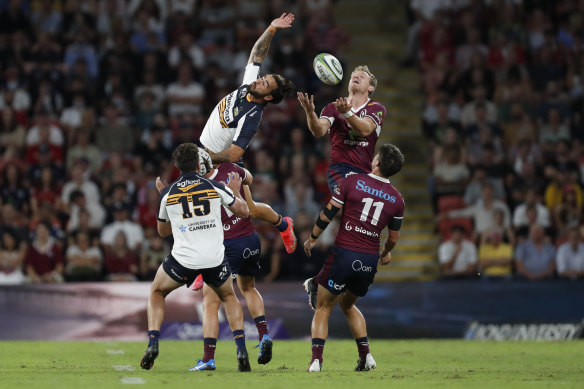 Brumbies winger Andy Muirhead reaches for the ball but Reds fullback Bryce Hegarty has it covered.
