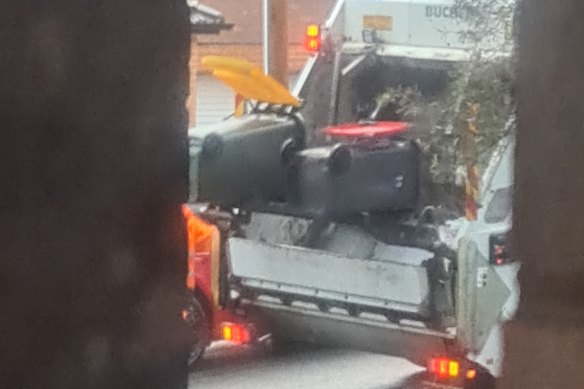 A garbage truck mixes contents of yellow and red bins in Earlwood.