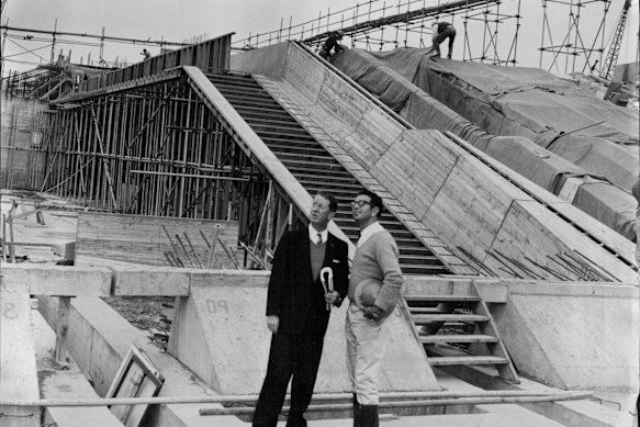 R. J. Thomson, secretary of the Sydney Opera House executive committee (left), and A. Levy, resident engineer, with the concourse behind them. The Monumental Steps were among the first parts of the project to be completed in 1961.