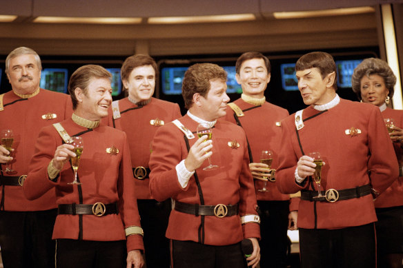 Members of the <i>Star Trek</i> crew, from left, James Doohan, DeForest Kelley, Walter Koenig, William Shatner, George Takei, Leonard Nimoy and Nichelle Nichols on the set of Paramount Studios in Los Angeles in 1988.
