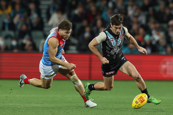 Zak Butters on the run against Jack Viney of the Demons.