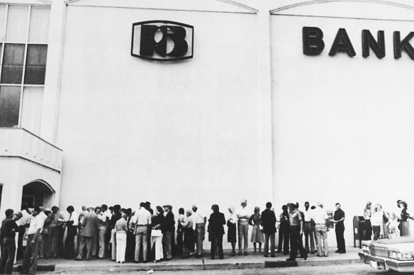 Клиенты стоят в очереди, чтобы попытаться снять свои деньги из Penn Square Bank в Оклахома-Сити в 1982 году.