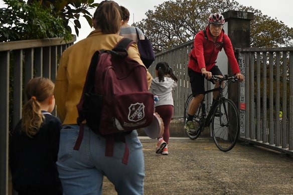 A cyclist passes students and parents approaching the entrance to Fort Street Public School in Millers Point.