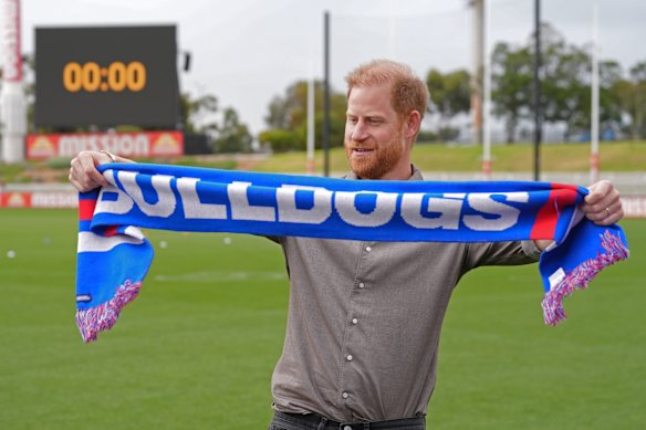 Prince Harry brandishes a Western Bulldogs scarf.