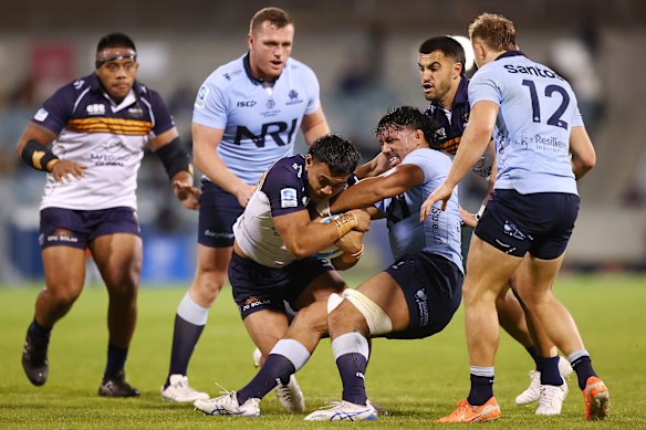 Len Ikitau of the Brumbies is tackled by the Waratahs