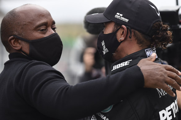 Hamilton (right) embraces his father Anthony after Sunday’s win.