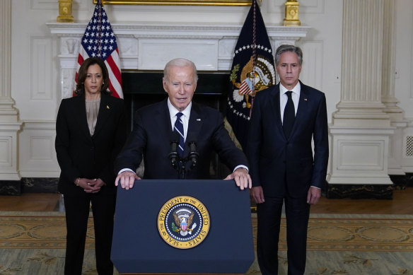 US President Joe Biden, center, speaks with Secretary of State Antony Blinken, right, and Vice President Kamala Harris in the State Dining Room of the White House.