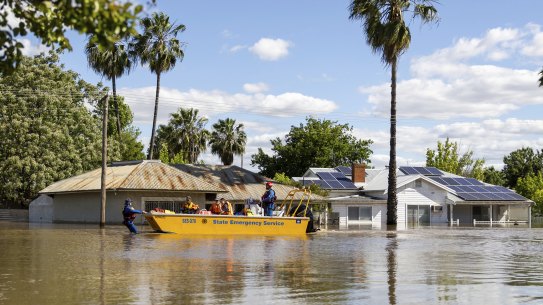 Emergency crews working at transporting people by boat over flooded streets in Forbes, NSW, last week. 