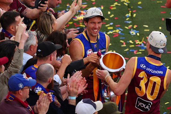 Darcy Fort celebrates with the premiership cup.