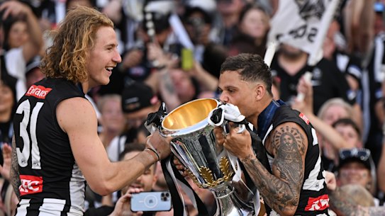 Beau McCreery holds the premiership cup while Bobby Hill kisses it.