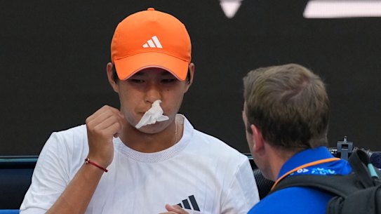 Learner Tien of the US receives treatment for a nose bleed during his fourth round match against Daniil Medvedev of Russia.
