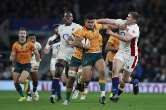 Englandâs Owen Farrell, right, tries to tackle Australiaâs Hunter Paisami.